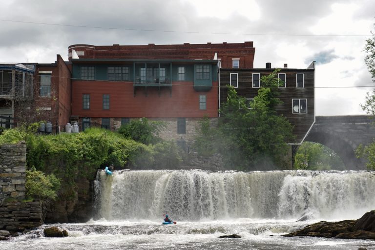 Noah G kayaks over Otter Creek Falls as Jordan Vickers looks on from below